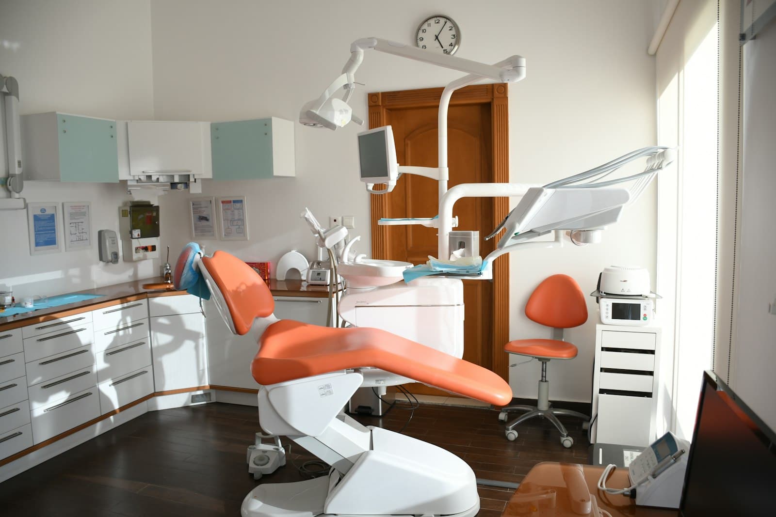 The treatment room at Dr Sandeep's Dental Care: a dental chair beside a window, with the overhead light and instrument tray.